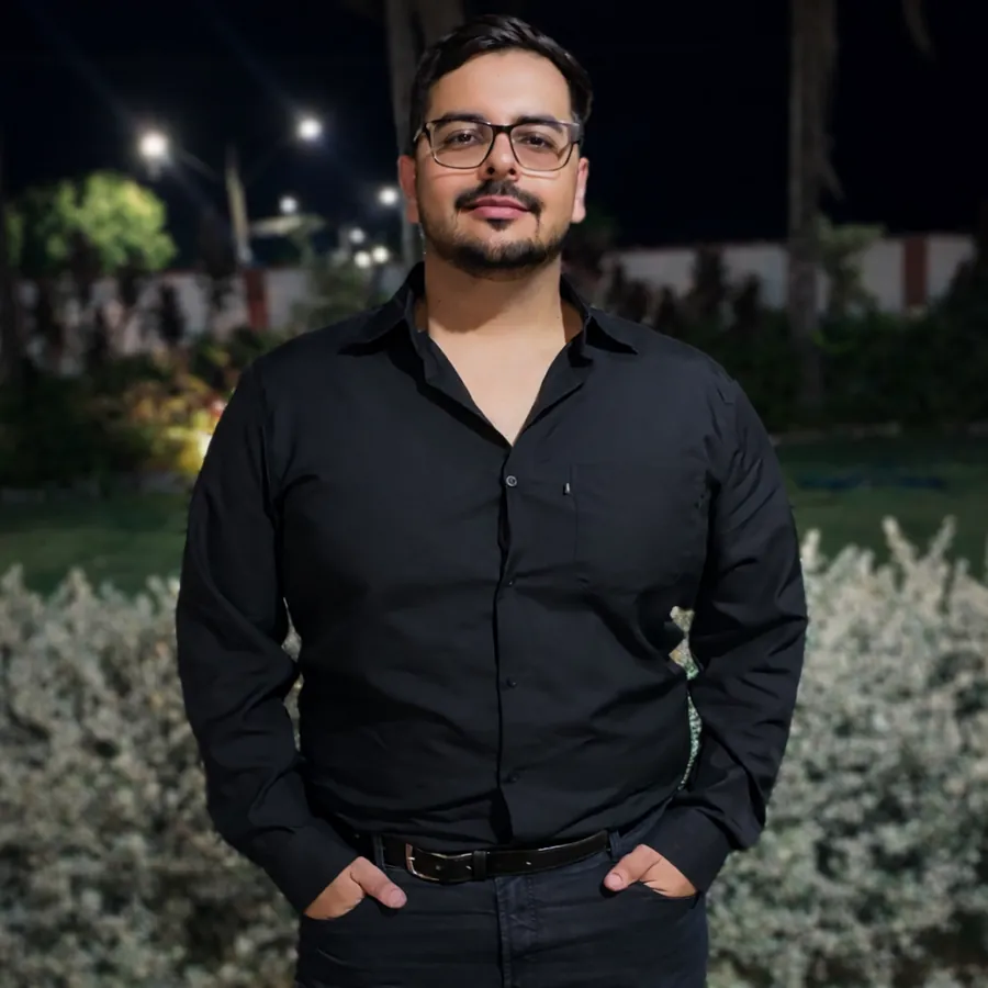 Rafael Flor, de camisa preta, em frente a um jardim à noite